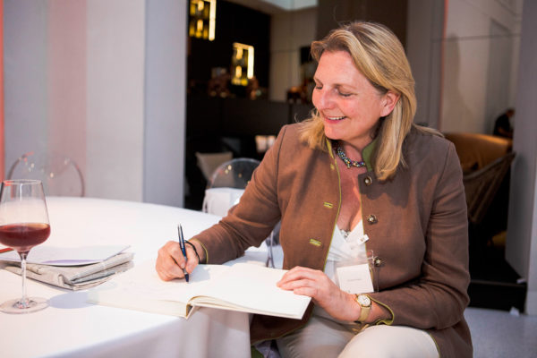 Karin Kneissl schreibt in das Gästebuch von Barbara Bertolini