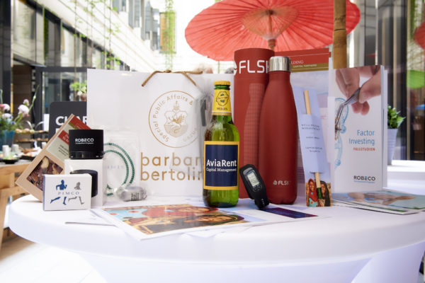 Das Goodie-Bag 2018 war gefüllt mit einer Laufuhr und einem exklusiven Ladekabel (Pimco), einem Lautsprecher (Robeco), einer FLSK-Getränkeflasche und einer Bio-Nussmischung (Golding Capital Partners), Minzbonbons (Union Investment), Sprout-Pencil (Wellington), Kugelschreiber mit integriertem USB-Stick (AGI), Mousepad (Mainfirst) und von AviaRent gab es eine Bierflasche passend zum Mittagessen, dem Wiener Würstelstand